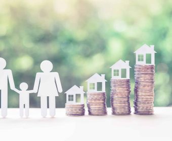 Home or mortgage loan concept : Family members, house model on stack of coins, depicts funds or short-term loans, a program offers assistance to members by providing cheap financing for housing needs